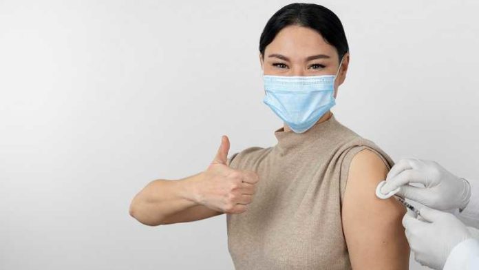 female-patient-with-medical-mask-showing-thumbs-up-as-she-gets-vaccine-shot