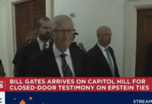 Bill Gates betrapt op een grijns terwijl hij een besloten Epstein-hoorzitting binnengaat, afgeschermd van het publiek